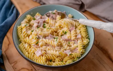 Fusilli-Nudeln mit einer cremigen **Schinken Sahne Sauce**, garniert mit Petersilie. Ein köstliches Gericht, das zum Genießen einlädt.