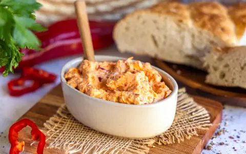 Cremiger Ajvar Feta Dip mit frischer Petersilie und Paprika, serviert mit rustikalem Brot.