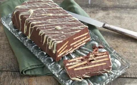 Kalter Hund mit Schokolade und Sahne: Ein Schichtkuchen aus Keksen und Schokomasse, verziert mit weißer Schokolade.