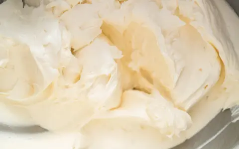 Cremige Buttercreme mit Pudding, die in einer Schüssel aufgeschlagen wird.