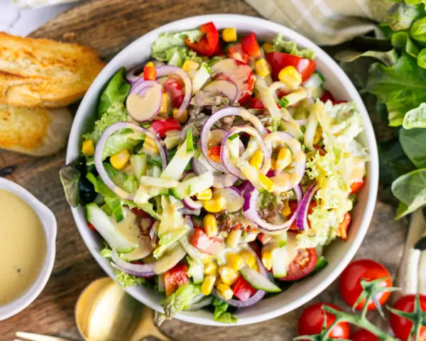 Frischer gemischter Salat mit Tomaten, Gurken, Mais und roten Zwiebeln, perfekt als leichtes Mittagessen. Ein tolles gemischter salat rezept!