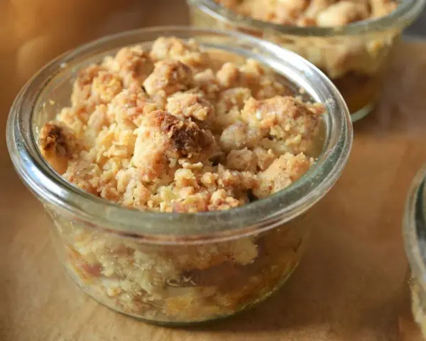 Leckerer Apfel Crumble in einem Glas, goldbraun gebacken, mit knuspriger Streuseldecke.