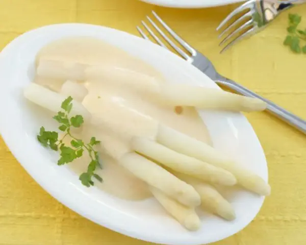 Spargel mit cremiger sauce hollandaise ohne ei, garniert mit Petersilie. Ein Genuss für jeden Gaumen.