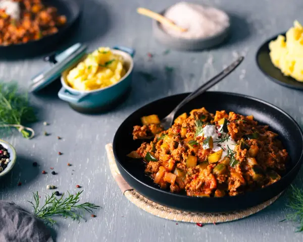 Schmorgurken mit Hack nach Omas Rezept, serviert mit Kartoffelbrei. Ein deftiges Gericht, das Erinnerungen weckt.