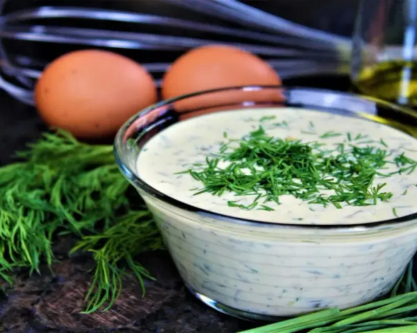 Schüssel mit cremiger Remoulade, garniert mit Dill. Eier und Kräuter deuten auf ein authentisches Remoulade Rezept Original hin.
