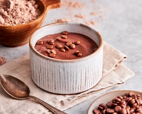 Schokoladenpudding, frisch zubereitet, mit Schokostückchen garniert. Perfekt, um Pudding selber machen zu lernen.