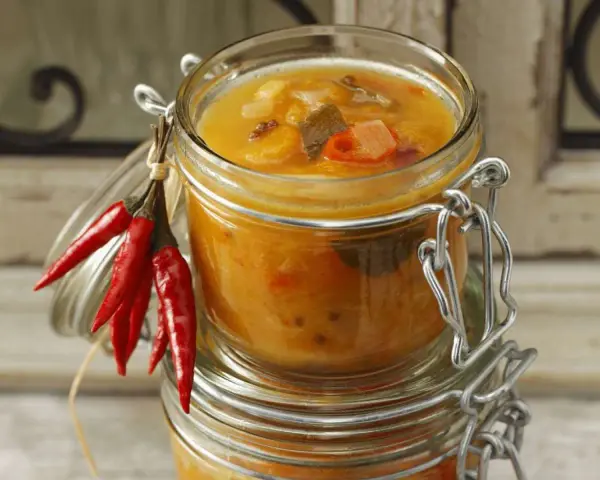 Ein Glas mit leckerem Aprikosen-Chutney-Rezept, garniert mit roten Chilis. Perfekt für herzhafte Gerichte.