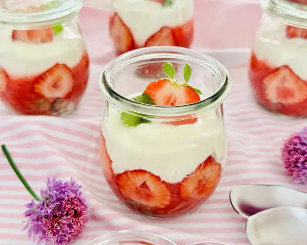 Erdbeer Dessert schnell im Glas geschichtet mit Sahne und frischen Erdbeeren, garniert mit Minze. Perfekt für den Sommer!