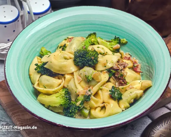 Eine Schüssel mit Tortellini in cremiger Sauce, garniert mit Brokkoli und Speck. Perfekt für eine schnelle Sauce zu Tortellini.