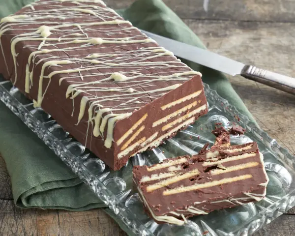 Kalter Hund mit Schokolade und Sahne: Ein Schichtkuchen aus Keksen und Schokomasse, verziert mit weißer Schokolade.