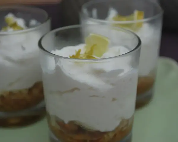 Erfrischendes Limoncello Creme Rezept in Gläsern geschichtet, garniert mit Zitronenspalten.