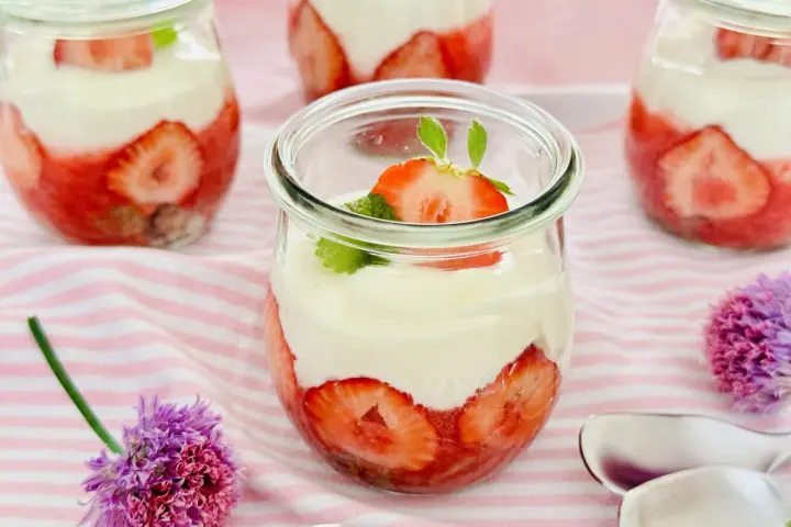 Erdbeer Dessert schnell im Glas geschichtet mit Sahne und frischen Erdbeeren, garniert mit Minze. Perfekt für den Sommer!