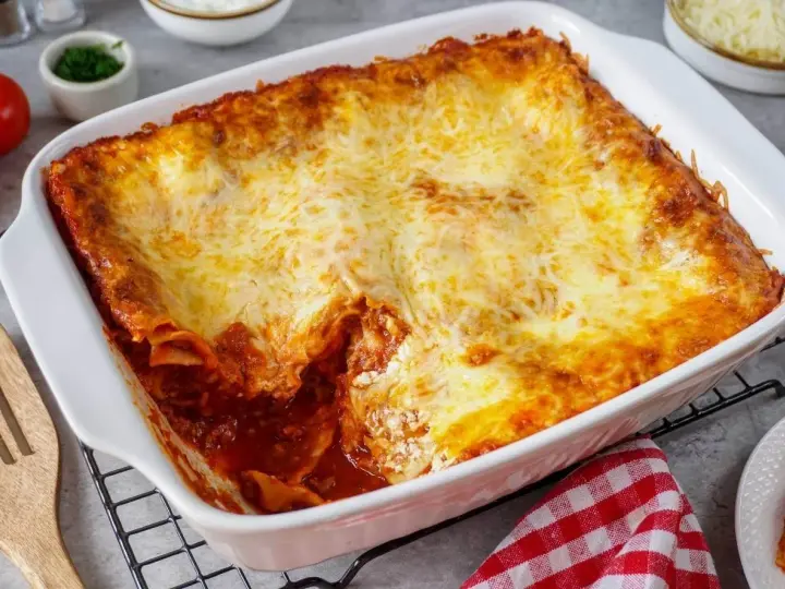 Herzhafte Lasagne mit Schmand und goldbraun überbackenem Käse in einer weißen Auflaufform.