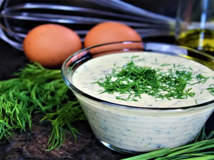 Schüssel mit cremiger Remoulade, garniert mit Dill. Eier und Kräuter deuten auf ein authentisches Remoulade Rezept Original hin.