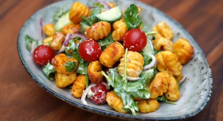 Herzhafter Gnocchi Salat mit Kirschtomaten, Gurken und einem cremigen Dressing.