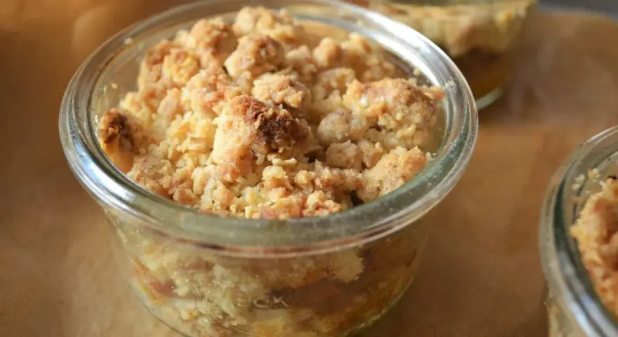 Leckerer Apfel Crumble in einem Glas, goldbraun gebacken, mit knuspriger Streuseldecke.