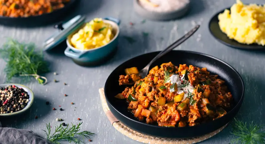 Schmorgurken mit Hack nach Omas Rezept, serviert mit Kartoffelbrei. Ein deftiges Gericht, das Erinnerungen weckt.
