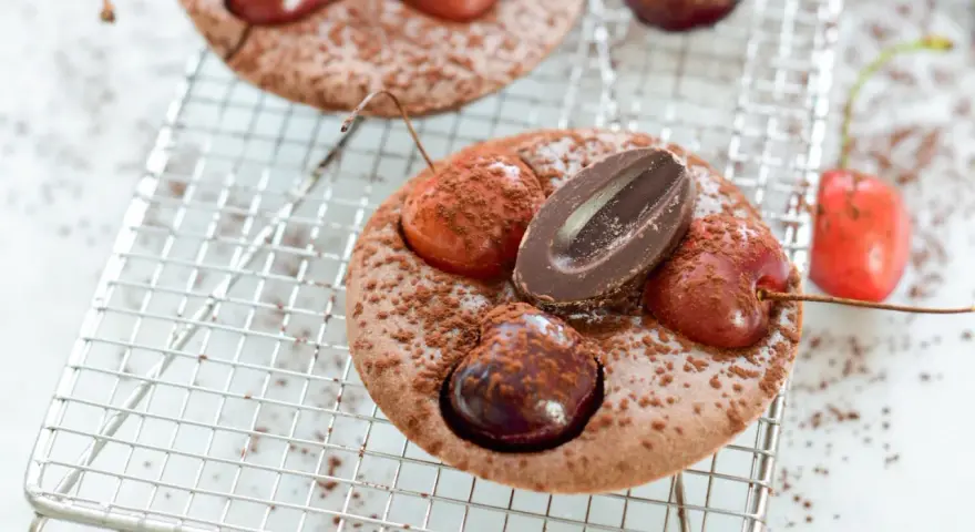 Schokoladen-Clafoutis mit Kirschen und Schokostückchen, ein köstliches clafoutis rezept original, bestäubt mit Kakaopulver.