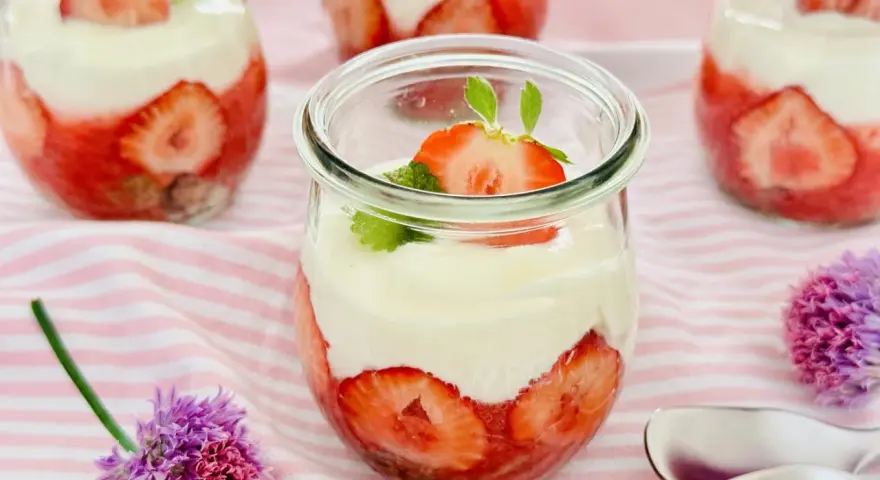 Erdbeer Dessert schnell im Glas geschichtet mit Sahne und frischen Erdbeeren, garniert mit Minze. Perfekt für den Sommer!