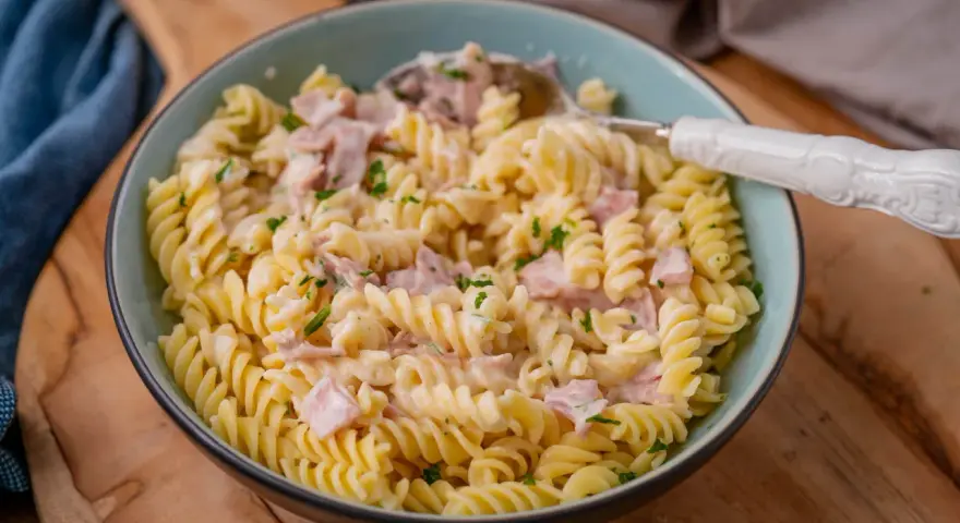 Fusilli-Nudeln mit einer cremigen **Schinken Sahne Sauce**, garniert mit Petersilie. Ein köstliches Gericht, das zum Genießen einlädt.