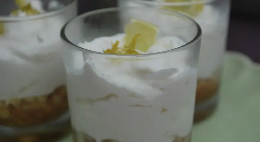 Erfrischendes Limoncello Creme Rezept in Gläsern geschichtet, garniert mit Zitronenspalten.