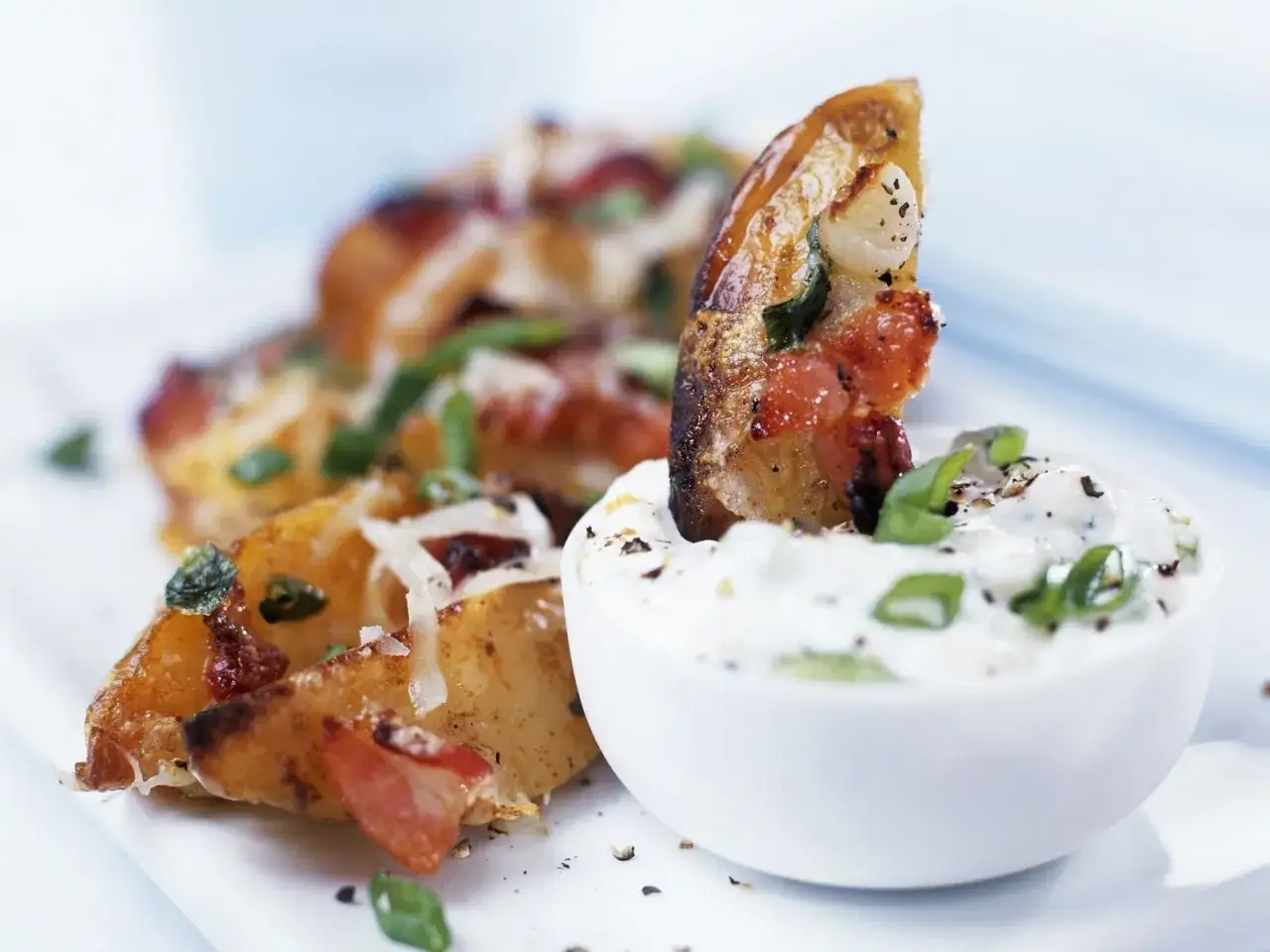 Knusprige Kartoffelecken mit Speck und K&auml;se, getunkt in cremige sour cream.