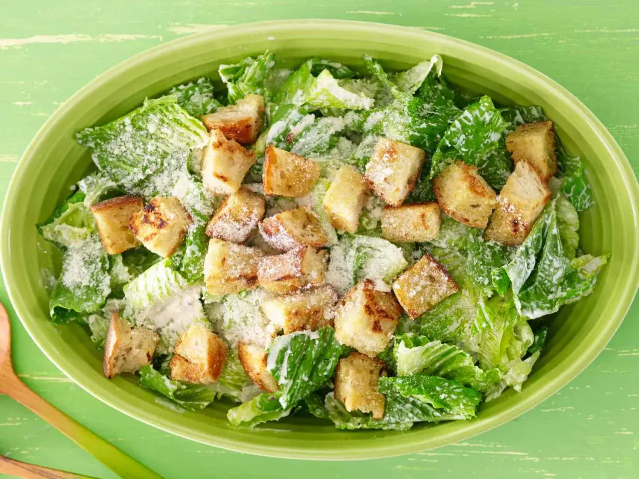 Frischer Caesar Salat mit knusprigen Croutons und cremigem Caesar Salat Dressing, bestreut mit Parmesan.