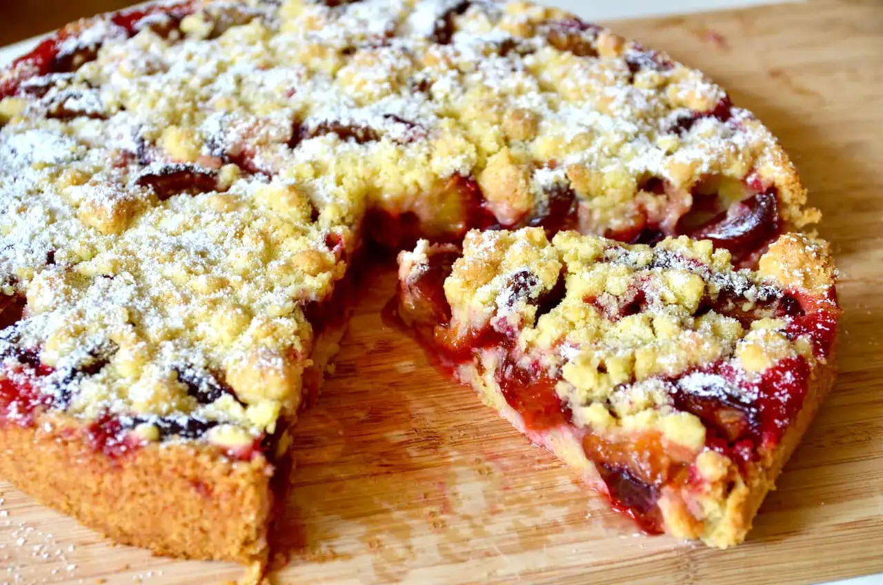 Saftiger Pflaumenkuchen ohne Hefe in einer Springform, bestreut mit Puderzucker und Streuseln. Ein Genuss!
