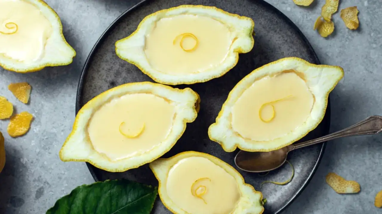 Erfrischendes Limoncello Creme Rezept, serviert in Zitronenschalen. Ein s&uuml;&szlig;er Genuss mit Zitrusnote.