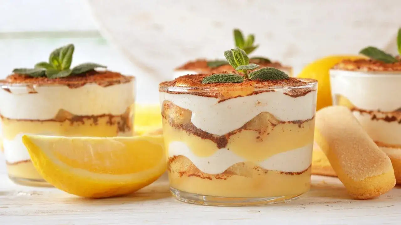 Erfrischender Limoncello Tiramisu im Glas, geschichtet mit L&ouml;ffelbiskuits, Zitronencreme und Kakao, garniert mit Minze.