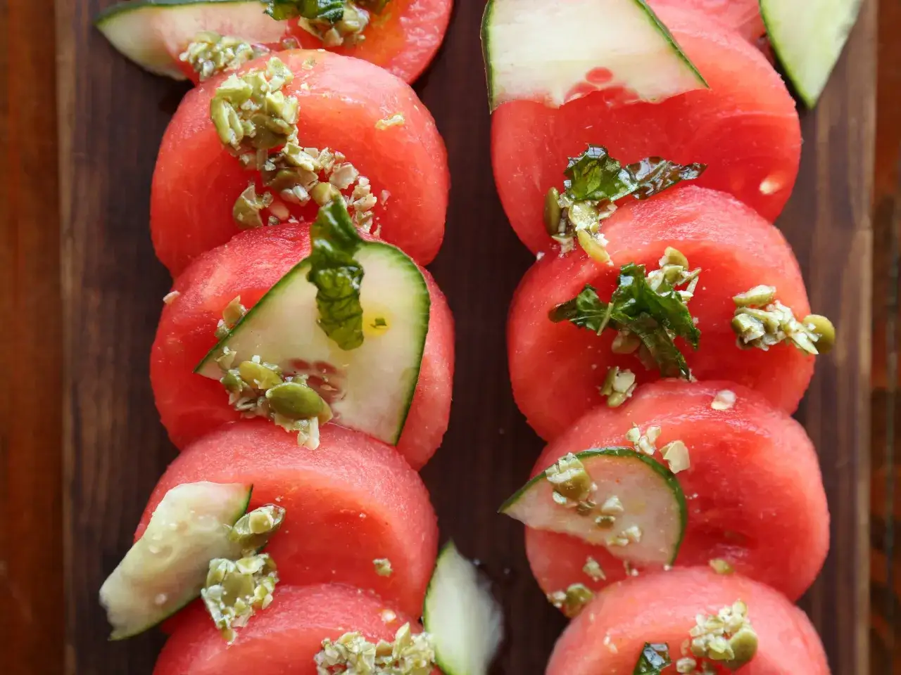 Martina und Moritz' Melonen-Gurken-Salat: saftige Wassermelonenscheiben mit Gurkenst&uuml;cken und Kr&auml;utern garniert.