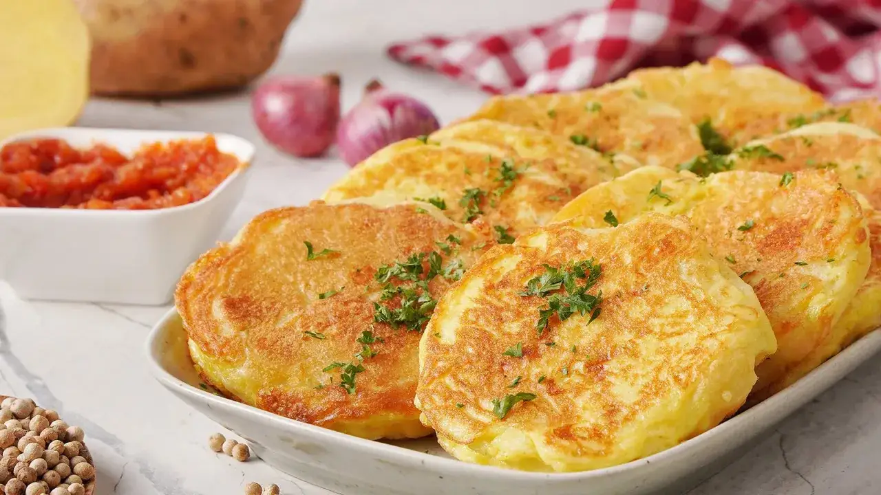 Goldbraune Kartoffelpuffer, garniert mit Petersilie, sind eine k&ouml;stliche Hauptspeise. Perfekt f&uuml;r Rezepte mit Kartoffeln als Hauptspeise.
