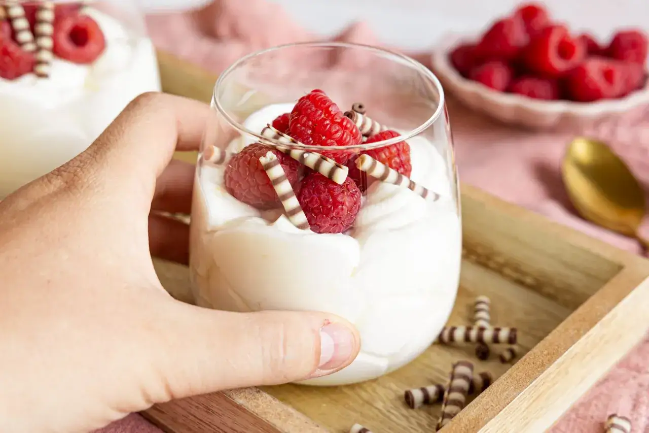 Ein cremiges Dessert mit Mascarpone, garniert mit frischen Himbeeren und Schokost&auml;bchen.