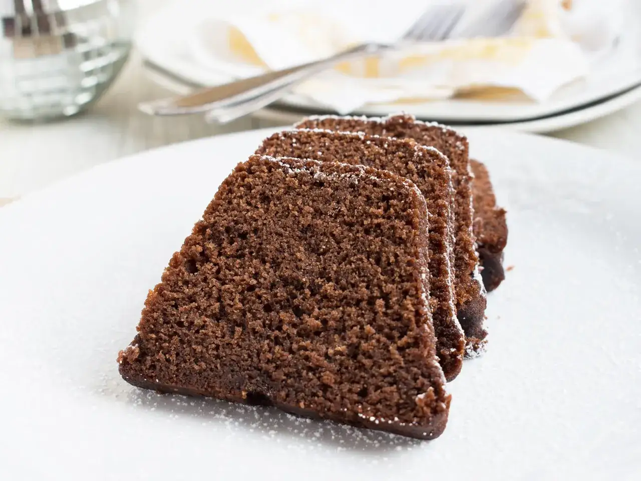 Saftige Scheiben eines Nutella Kuchens, der mit nur 3 Zutaten zubereitet wurde, best&auml;ubt mit Puderzucker.