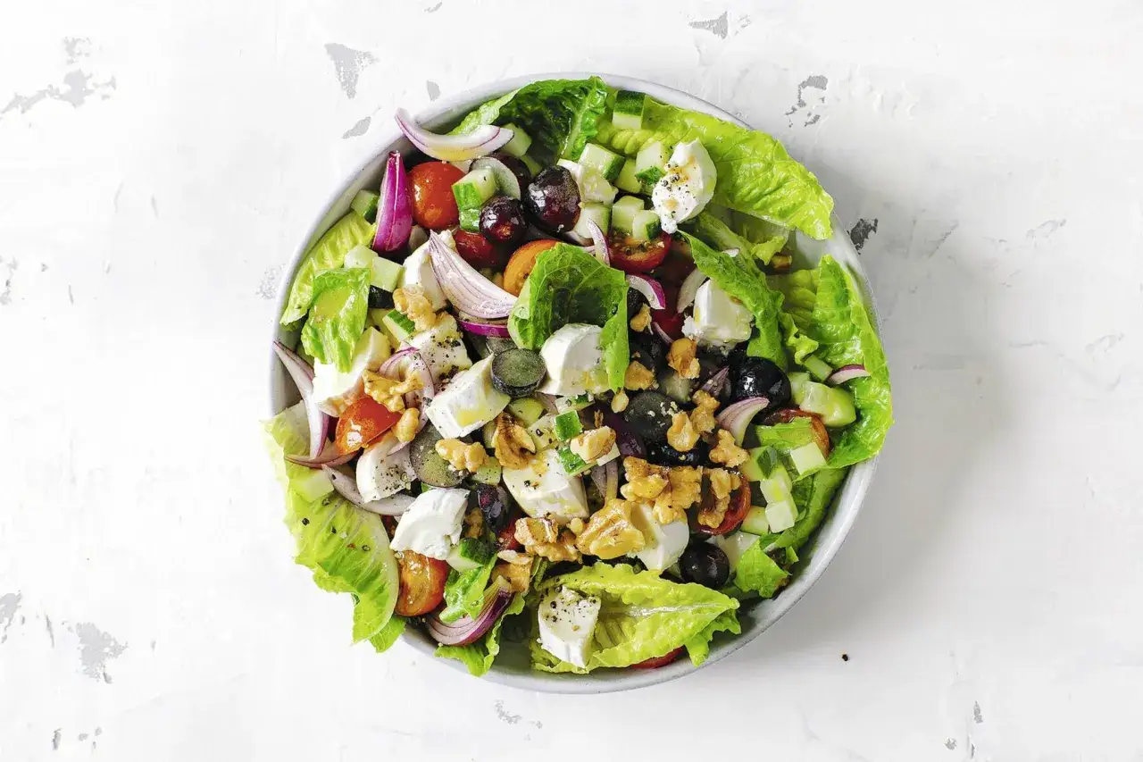 Frischer Salat mit knackigem Salat, Tomaten, Gurken, roten Zwiebeln, Oliven, Waln&uuml;ssen und cremigem Feta. Ein k&ouml;stlicher Weintrauben Feta Salat.