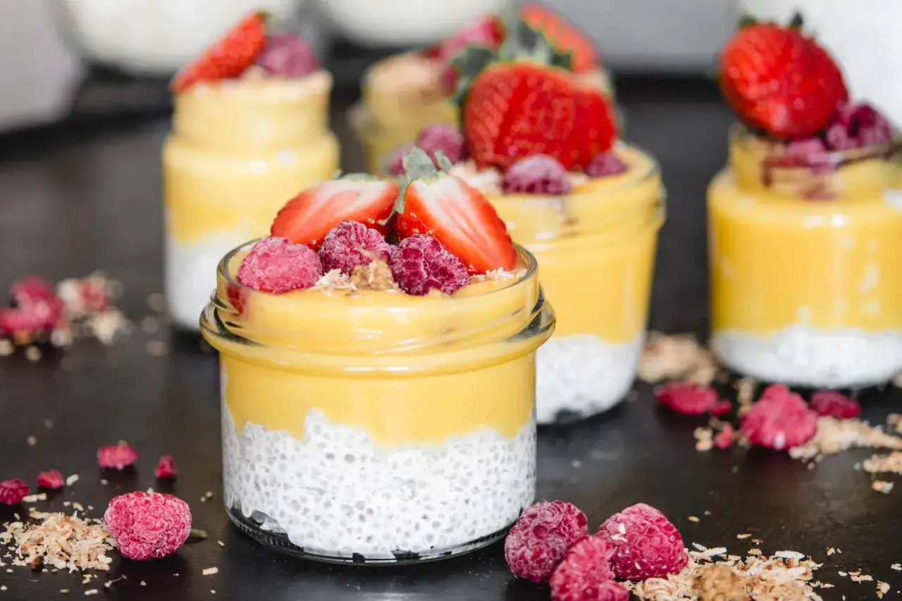 Erfrischender Chia Pudding mit Milch, garniert mit frischen Erdbeeren und Himbeeren. Ein gesunder Genuss!