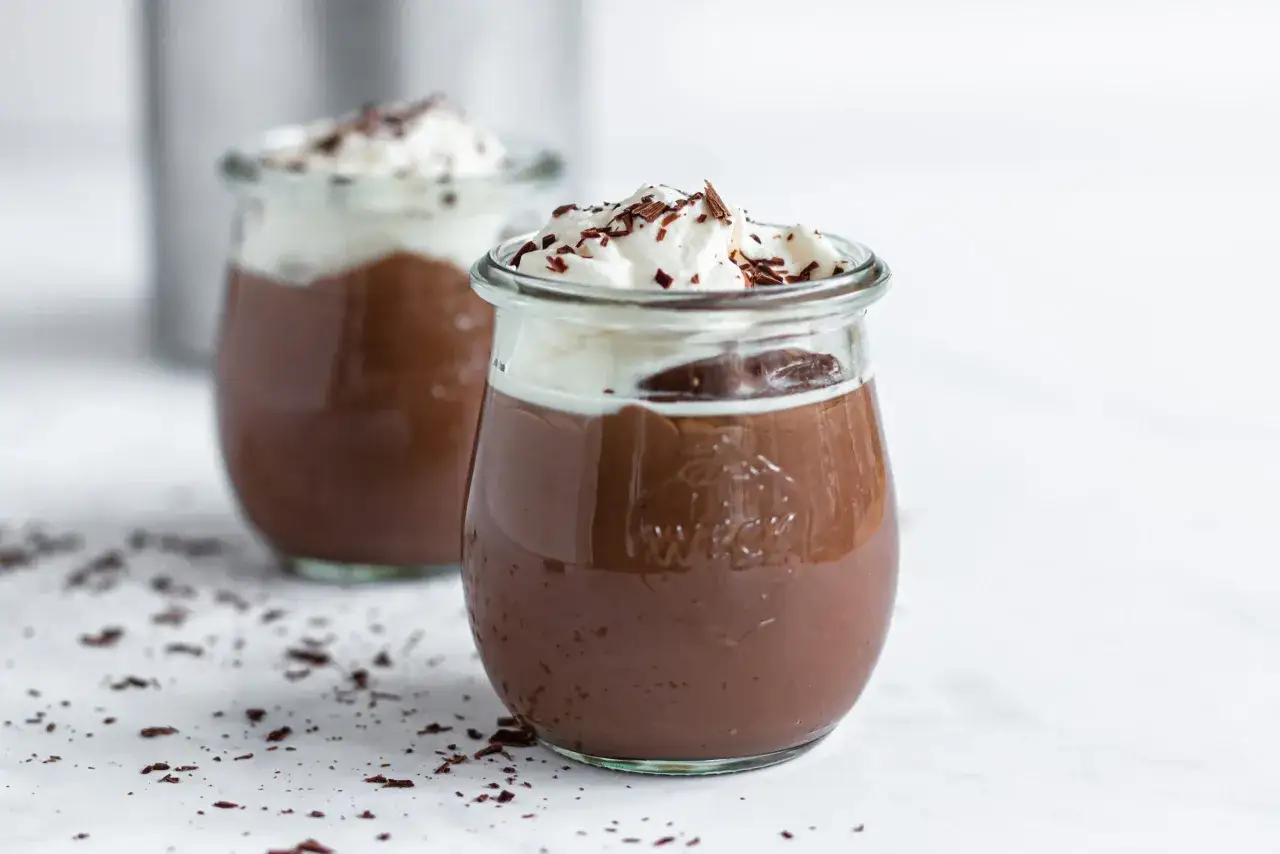 Zwei Gl&auml;ser mit selbstgemachtem Schokopudding, gekr&ouml;nt mit Sahne und Schokostreuseln. Ein Genuss, der zum Nachmachen einl&auml;dt.