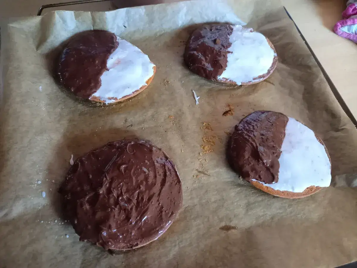 Vier frisch gebackene Kekse mit Schokoladen- und Zuckerguss-Glasur, bereit f&uuml;r das amerikaner Rezept.